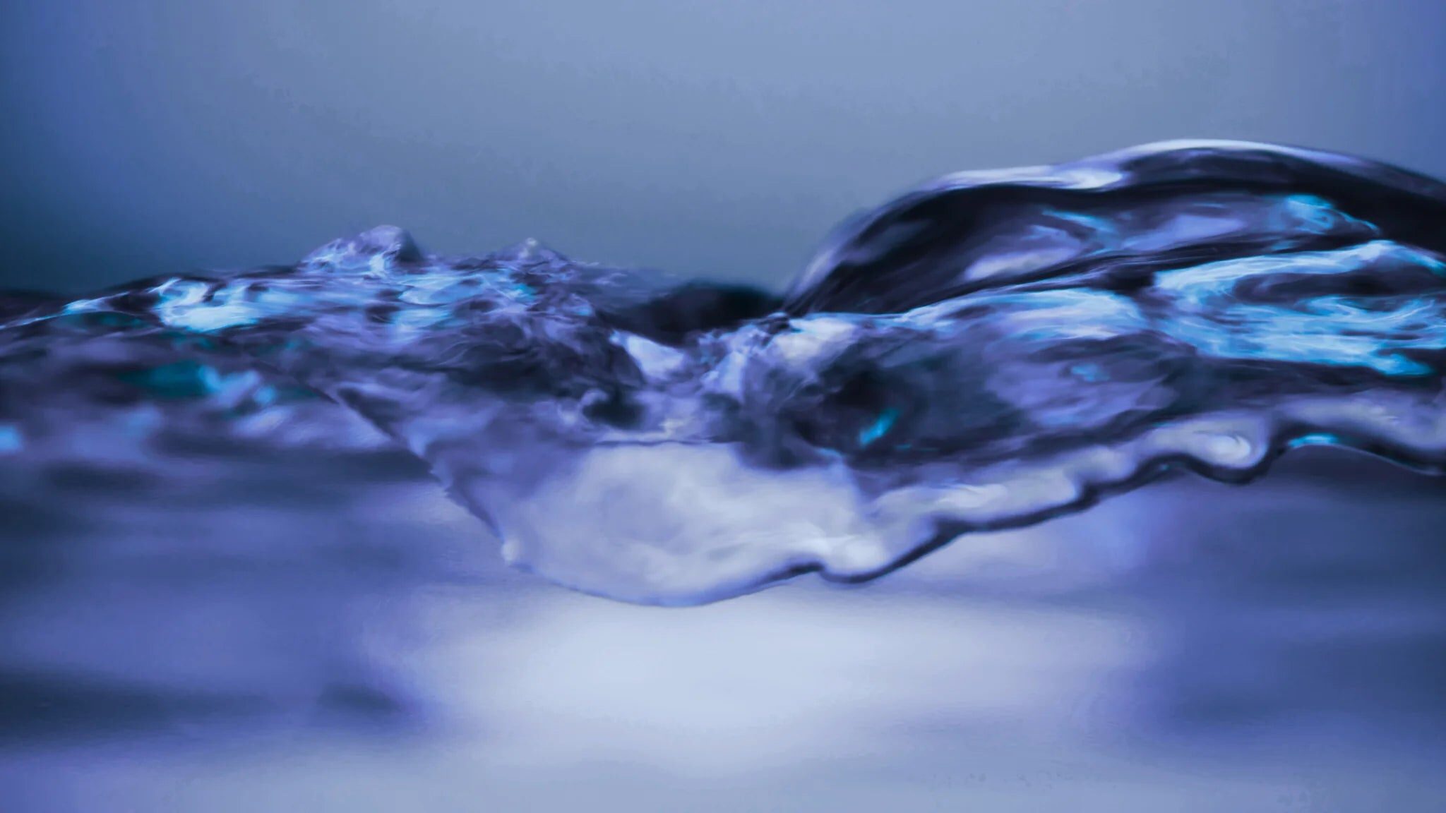 A calm ripple moving across still blue water